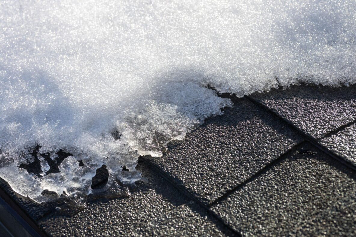 Snow melting off asphalt shingle roof in Ohio during February thaw
